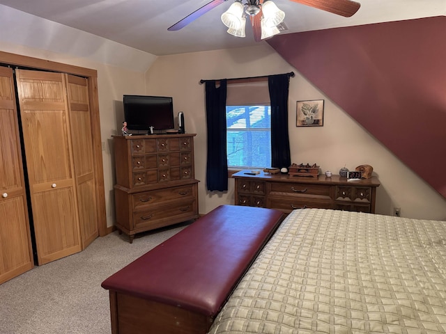 carpeted bedroom with ceiling fan, vaulted ceiling, and a closet