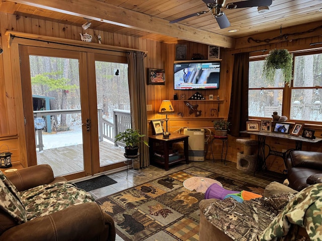 living room with french doors, wooden walls, ceiling fan, beam ceiling, and wood ceiling