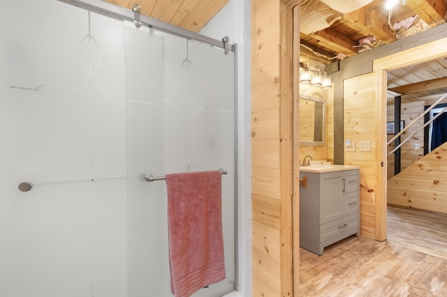 bathroom featuring vanity, hardwood / wood-style flooring, and wooden walls