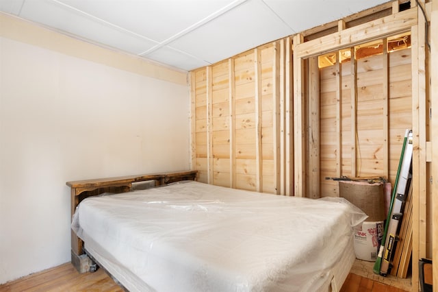 bedroom with wood-type flooring and wood walls