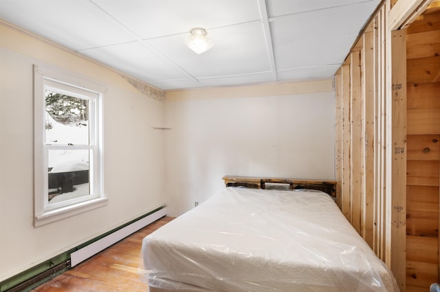 bedroom with a baseboard radiator and light hardwood / wood-style floors