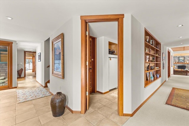 hall featuring built in shelves and light tile patterned floors