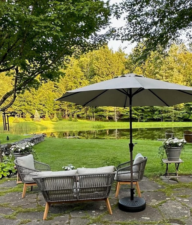 view of home's community with outdoor lounge area, a yard, and a water view