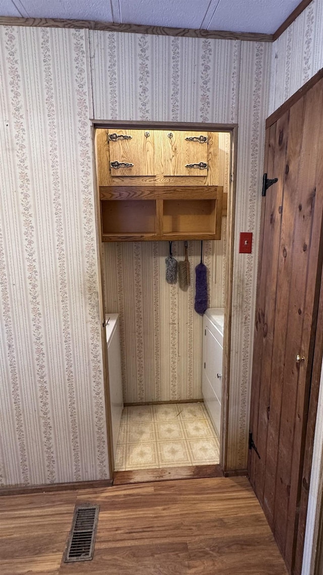 mudroom with wood-type flooring and a textured ceiling