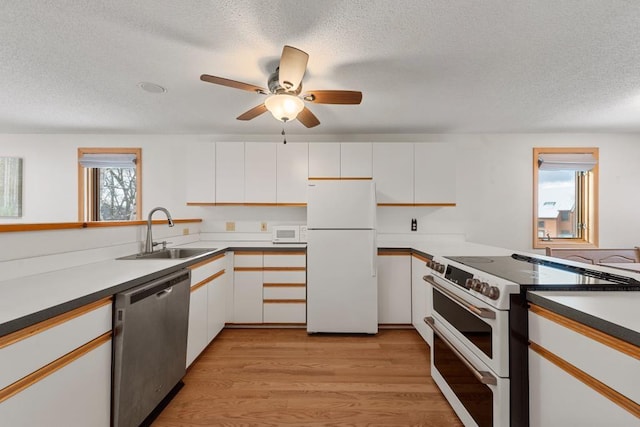 kitchen featuring a textured ceiling, white appliances, sink, light hardwood / wood-style flooring, and white cabinets