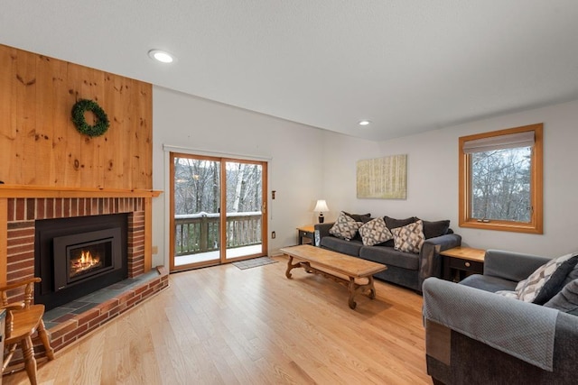 living room featuring light wood-type flooring and a brick fireplace