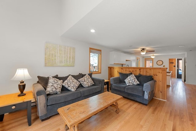 living room with light hardwood / wood-style flooring and ceiling fan