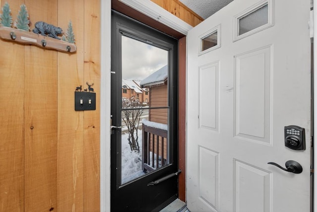 doorway to outside with a textured ceiling