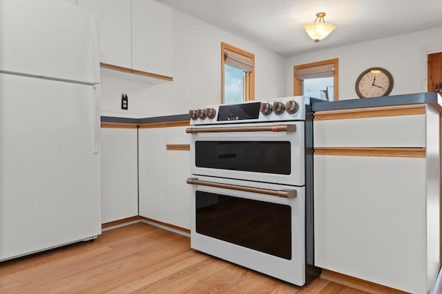 kitchen with white cabinets, light hardwood / wood-style floors, and white appliances