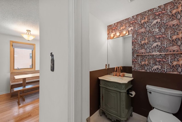 bathroom featuring hardwood / wood-style floors, vanity, a textured ceiling, and toilet