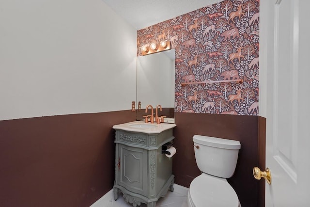 bathroom with tile patterned flooring, vanity, and toilet