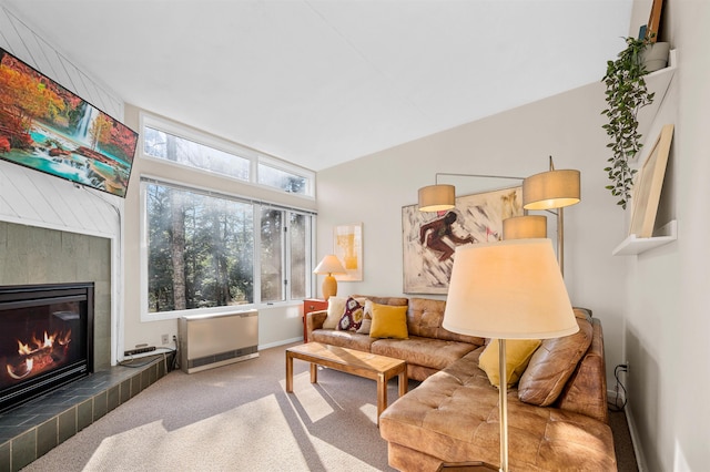 living room with carpet flooring, heating unit, vaulted ceiling, and a tiled fireplace