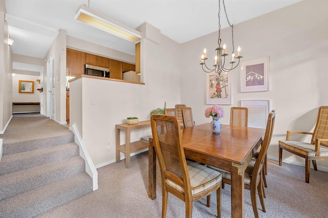 carpeted dining area with an inviting chandelier