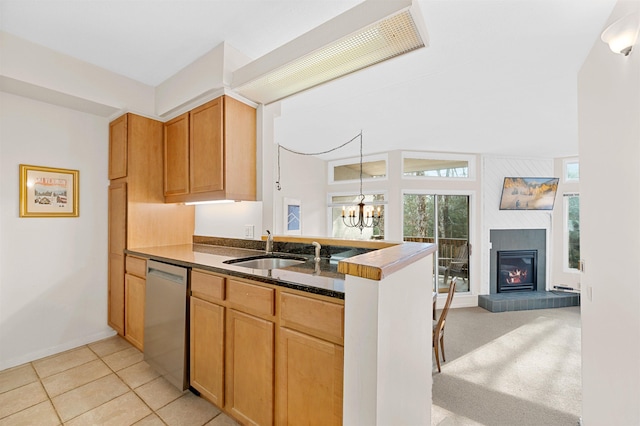 kitchen featuring a large fireplace, sink, an inviting chandelier, dishwasher, and light tile patterned flooring