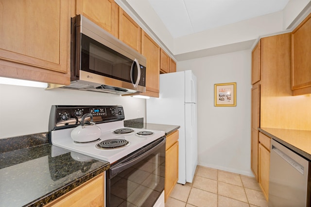 kitchen featuring appliances with stainless steel finishes, dark stone counters, and light tile patterned flooring