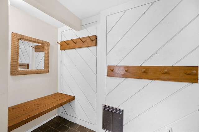 mudroom with beam ceiling and wooden walls