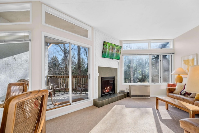 carpeted living room featuring a tile fireplace