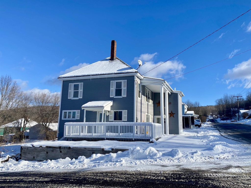 view of snowy exterior with a wooden deck