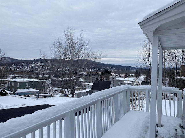 snow covered deck with a mountain view