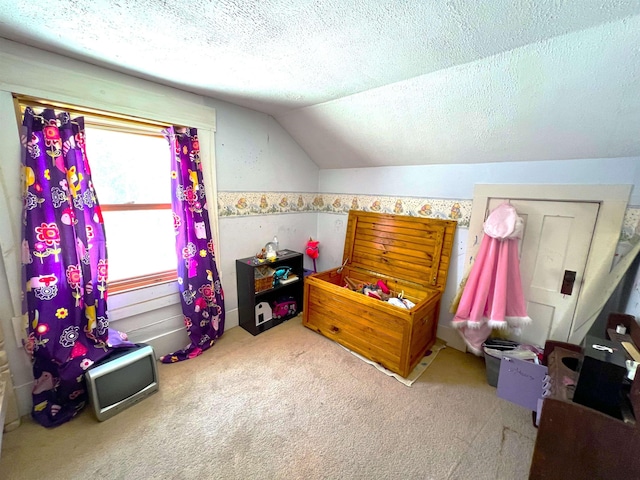 bedroom with a textured ceiling, carpet floors, and lofted ceiling