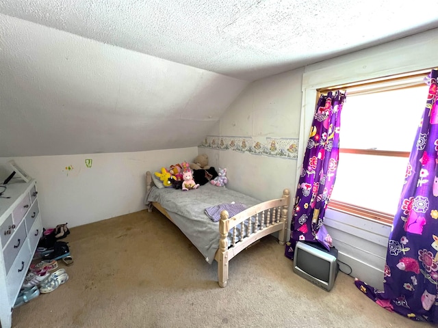 carpeted bedroom with a textured ceiling and vaulted ceiling