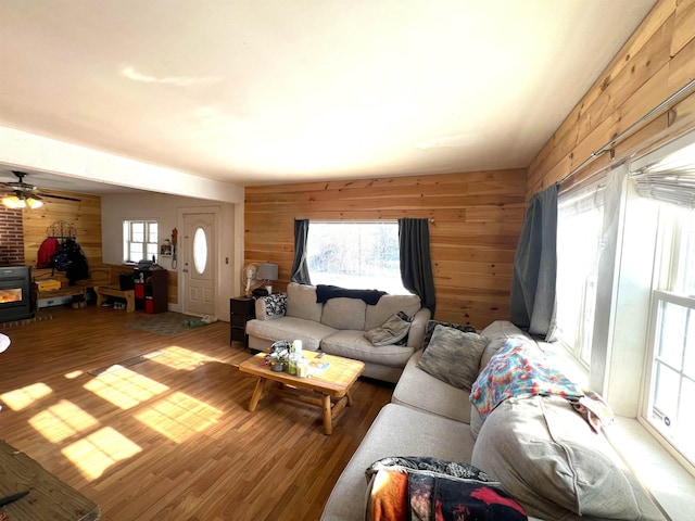 living room with hardwood / wood-style floors, wooden walls, and a wealth of natural light