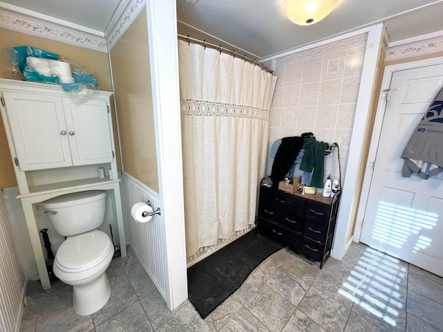 bathroom with a shower with curtain, toilet, tile walls, and crown molding