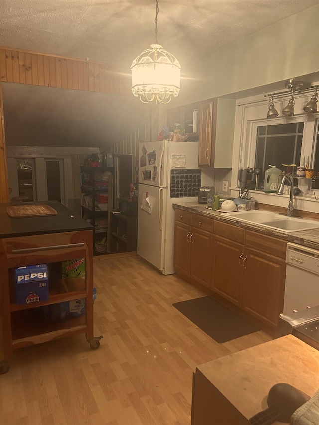 kitchen with sink, pendant lighting, a textured ceiling, white appliances, and light wood-type flooring