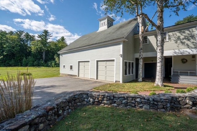 view of side of home featuring a yard and a garage