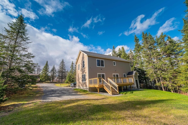 back of house with a lawn and a deck