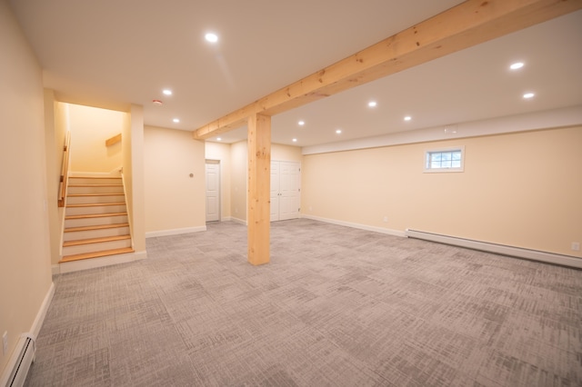 basement featuring light colored carpet and a baseboard heating unit