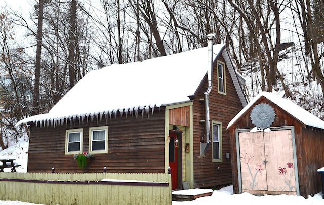 view of front of property featuring a shed