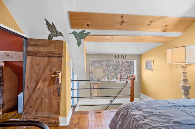 bedroom featuring lofted ceiling with beams and hardwood / wood-style flooring