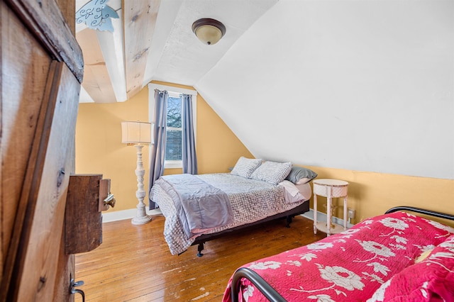 bedroom featuring wood-type flooring and vaulted ceiling