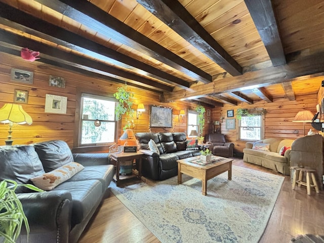 living room featuring wooden walls, hardwood / wood-style floors, a wealth of natural light, and beamed ceiling