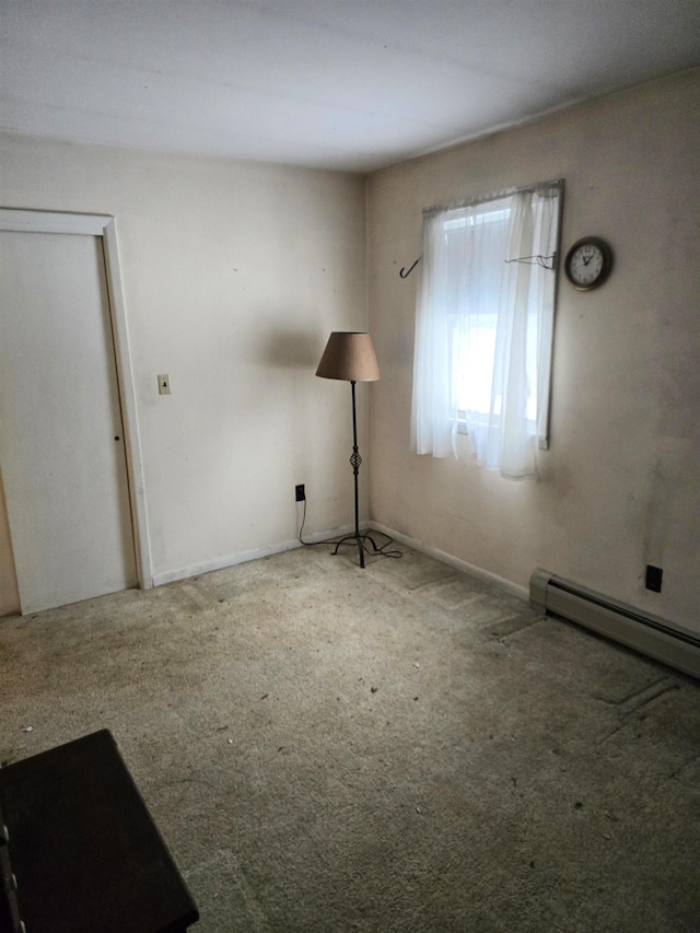 spare room featuring carpet and a baseboard heating unit