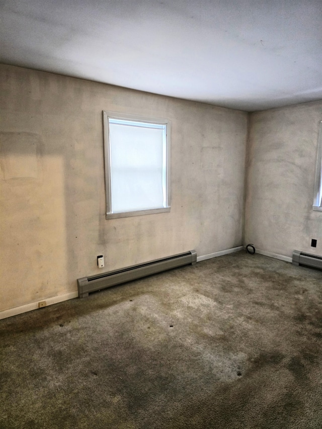 carpeted empty room featuring a baseboard radiator