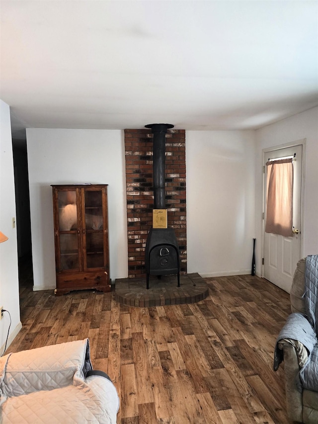 living room featuring a wood stove and dark hardwood / wood-style flooring