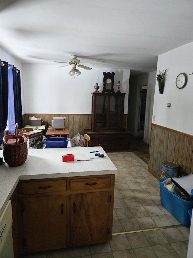 kitchen with dishwasher, ceiling fan, and wooden walls