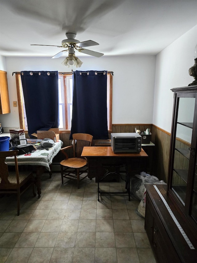 home office with ceiling fan and wooden walls