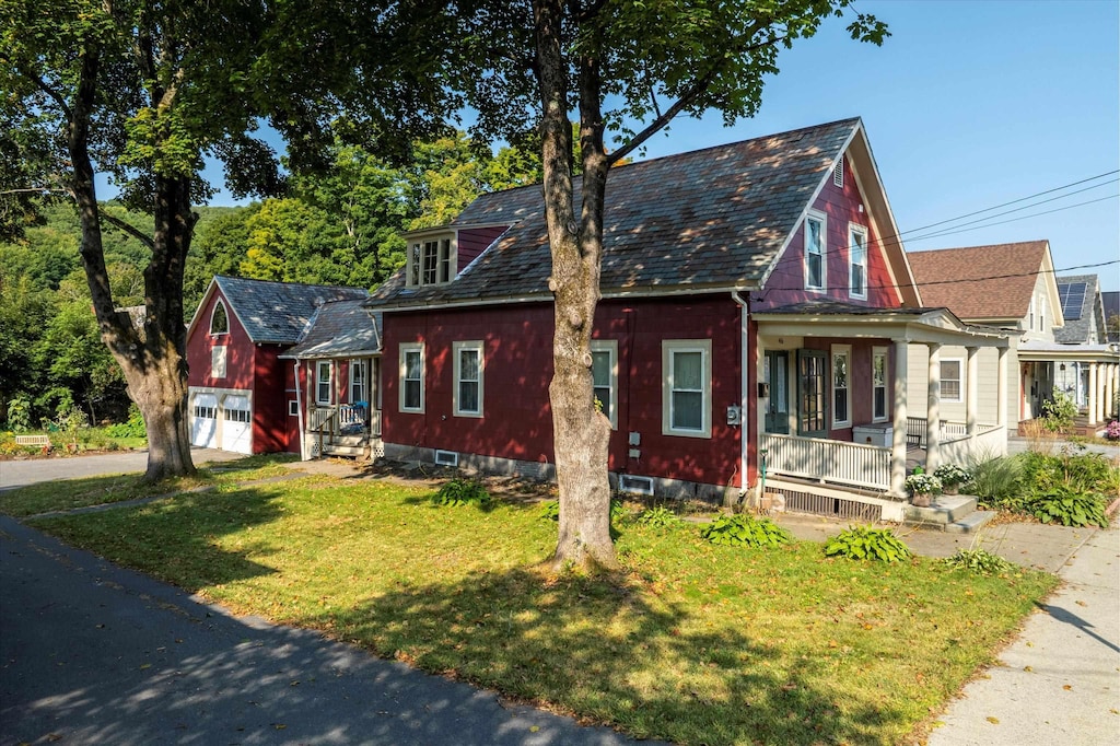 view of front of property with a front lawn, a porch, and a garage