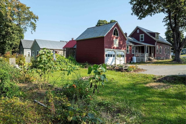 view of front of home featuring a front yard, a porch, and a garage