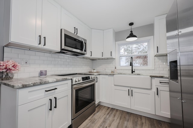 kitchen featuring sink, white cabinetry, stainless steel appliances, and light wood-type flooring