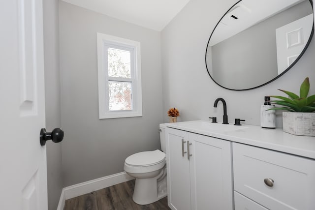 bathroom with hardwood / wood-style floors, vanity, and toilet