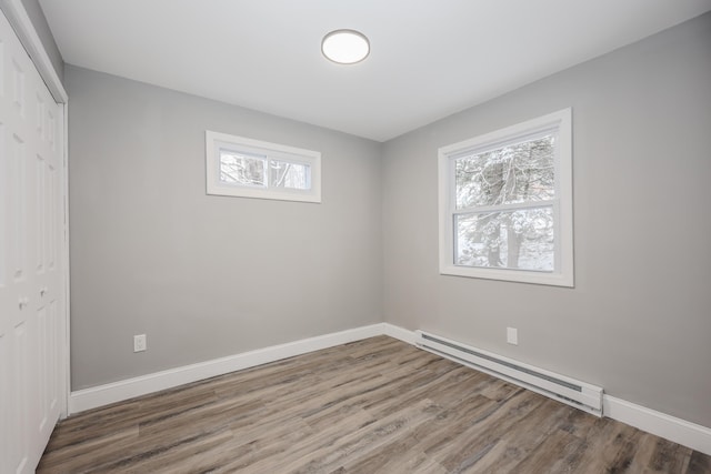 spare room with hardwood / wood-style floors and a baseboard radiator