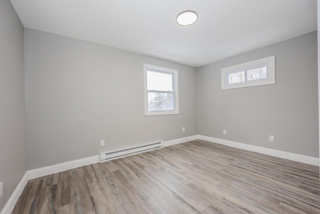 unfurnished room with wood-type flooring and a baseboard radiator