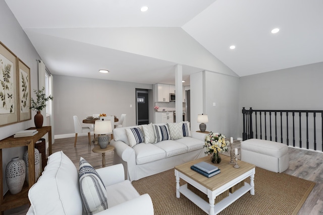 living room with light wood-type flooring and lofted ceiling