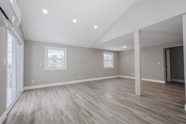 basement featuring a wall unit AC and light wood-type flooring