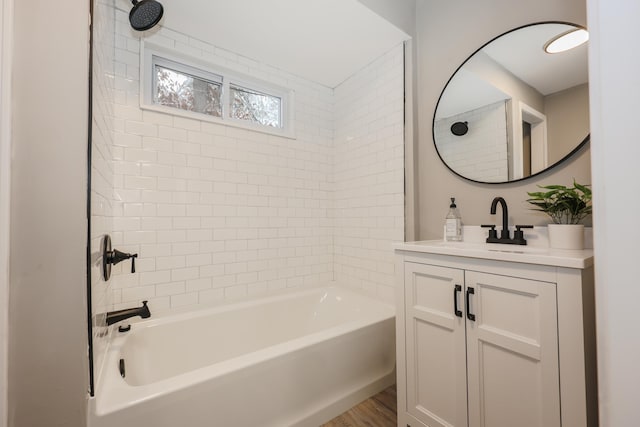 bathroom featuring hardwood / wood-style floors, vanity, and tiled shower / bath