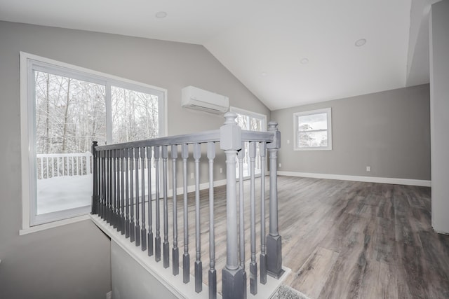 stairway with hardwood / wood-style flooring, an AC wall unit, and lofted ceiling